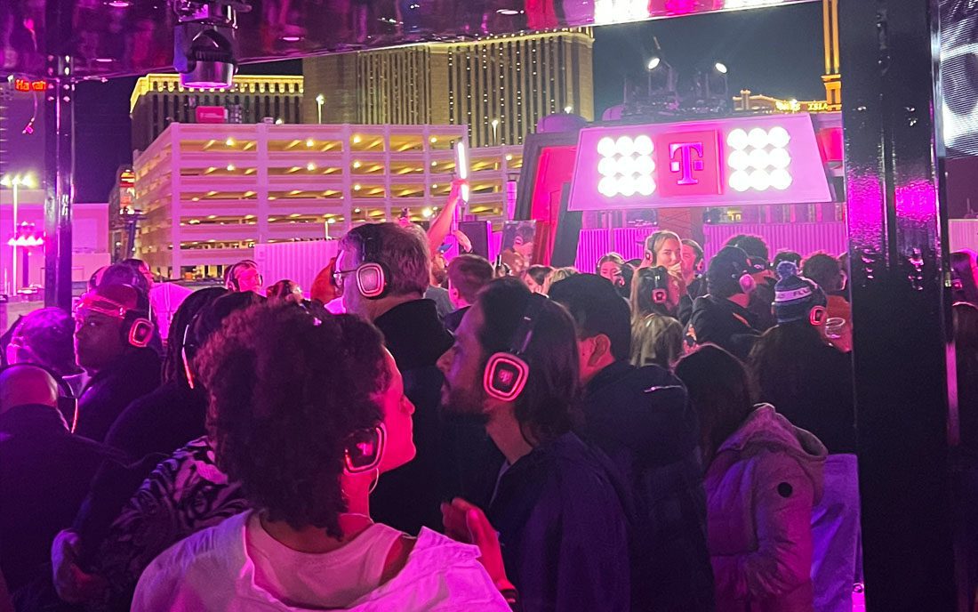 Audience wearing pink-glowing silent disco headphones at the T Mobile Zone at Formula 1 Las Vegas